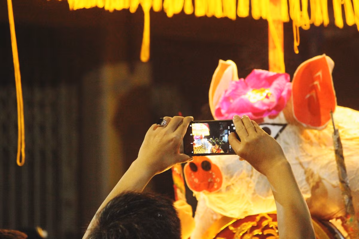 Nhiều người thích thú không quên ghi lại khoảnh khắc "ông lợn" được rước để khoe với bạn bè, người thân.