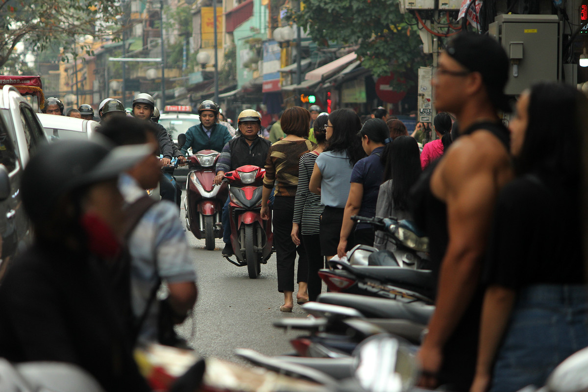 Những người đi bộ bị đẩy xuống lòng đường khiến các phương tiện tham gia lưu thông bị cản trở.