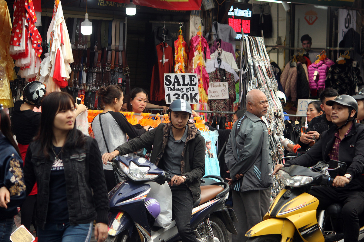 Nhiều cửa hàng treo biển giảm giá, hiên ngang bày khắp vỉa hè, chặn hết lối của người đi bộ.