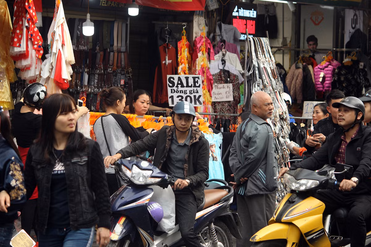 Nhiều cửa hàng treo biển giảm giá, hiên ngang bày khắp vỉa hè, chặn hết lối của người đi bộ.