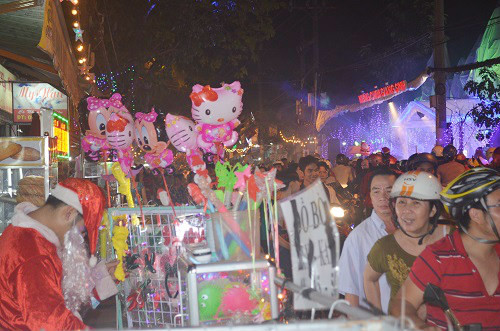 Hai bên đường bày bán nhiều đồ chơi với hình ảnh người dân đóng giả ông già Noel để thu hút khách mua.