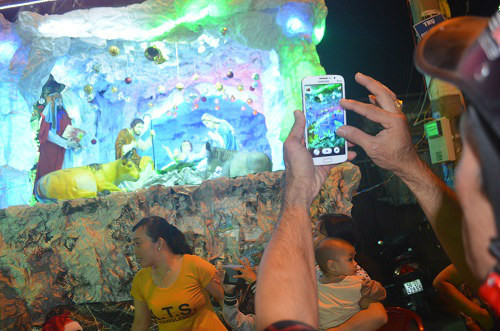 Người dân chụp hình lưu lại hình ảnh hang đá trang trí Chúa giáng sinh.