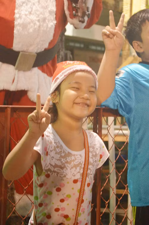 Một bé gái thích thú chụp hình kỉ niệm mùa Noel