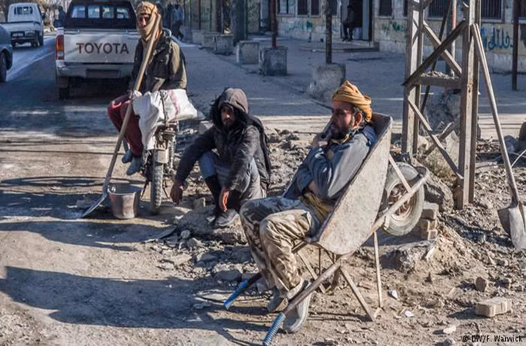 Một số lao động chân tay ngồi chờ việc tại một góc phố ở Raqqa. Việc tái thiết thành phố sẽ cần tới nhiều lao động như những người này.