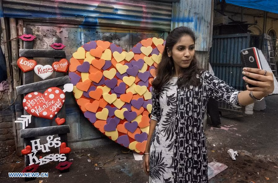 Cô gái chụp ảnh “tự sướng” với những hình trái tim trên đường phố Kolkata ngày 13/2.