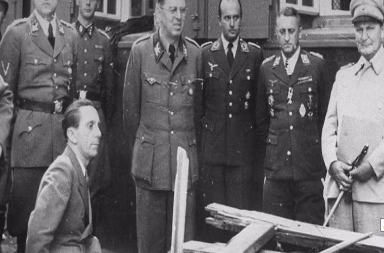 Joseph Goebells (ngồi) và Goering (áo trắng) xem xét chiếc bàn đã "cứu" trùm phát xít Đức Adolf Hitler trong vụ nổ bom mưu sát ở Wolfschanze năm 1944.