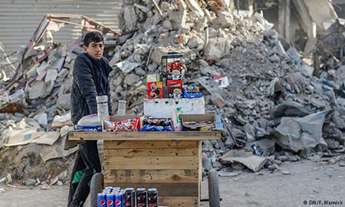 Một em nhỏ bán đồ uống ngay ngoài đường phố.