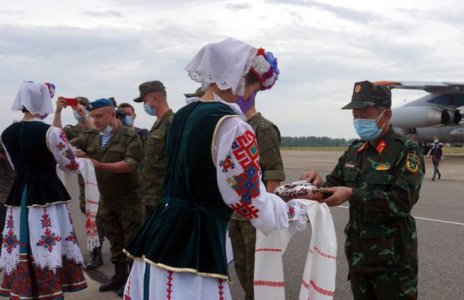 Các cô gái Belarus trong trang phục truyền thống đón đội tuyển Việt Nam và đội tuyển các nước với bánh mì và muối tại sân bay.