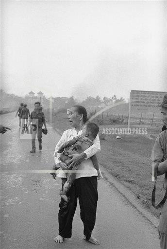 Hình ảnh quặn lòng người mẹ hoảng sợ, lo lắng, ôm con nhỏ bị cháy xém da thịt do ảnh hưởng của vụ dội bom napalm ở bên ngoài Trảng Bàng.