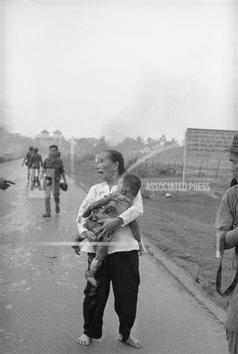 Hình ảnh quặn lòng người mẹ hoảng sợ, lo lắng, ôm con nhỏ bị cháy xém da thịt do ảnh hưởng của vụ dội bom napalm ở bên ngoài Trảng Bàng.