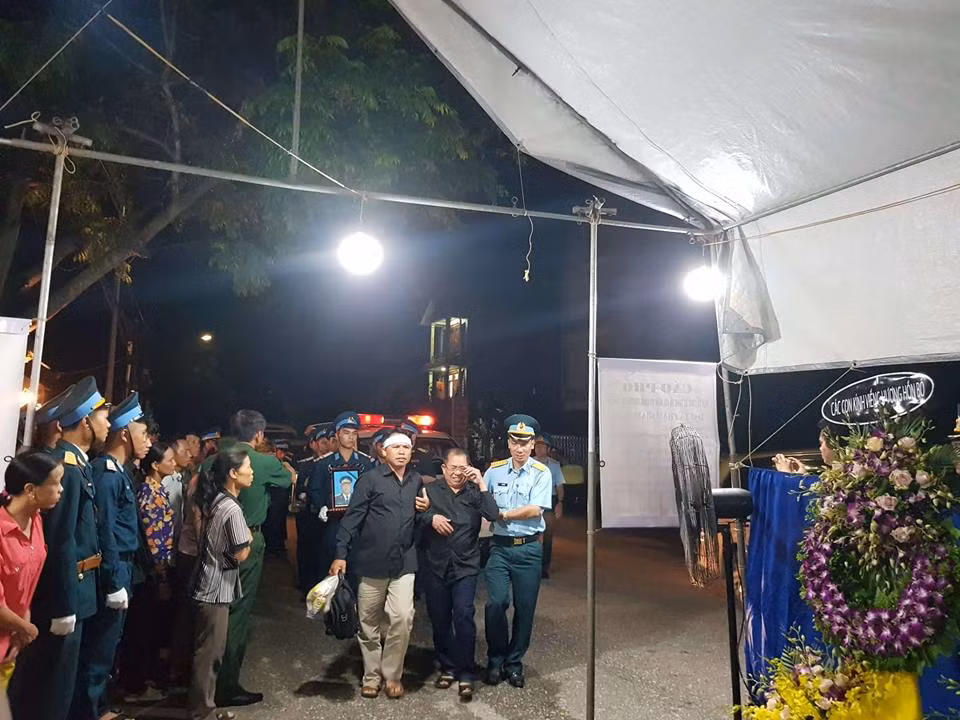 Người thân đại tá Phạm Giang Nam òa khóc rồi lặng nhìn hình ảnh đồng đội đưa di cốt của đại tá Nam được phủ trang trọng dưới lá cờ tổ quốc lên bàn thờ nơi tổ chức tang lễ.