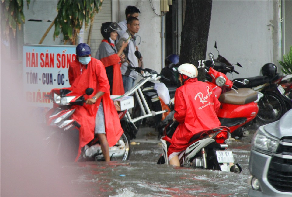Người đàn ông vật vã vượt qua đoạn ngập.
