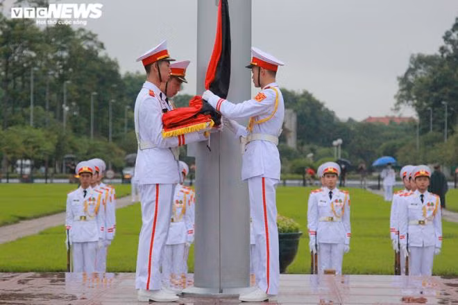 Ba chiến sĩ thực hiện nghi thức trang trọng tại chân cột cờ. Nghi lễ treo băng tang được thực hiện song song với nghi thức chào cờ thường ngày.