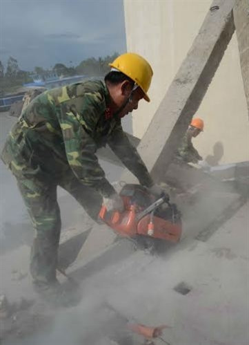 Sử dụng máy cắt bê tông cầm tay.