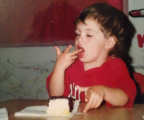 Bé thưởng thức từng chút bánh một bằng cách chấm rồi mút tay.