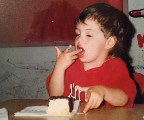 Bé thưởng thức từng chút bánh một bằng cách chấm rồi mút tay.