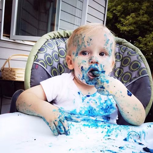 Ảnh chụp bé ăn bánh một mình lấm lem khắp mặt.