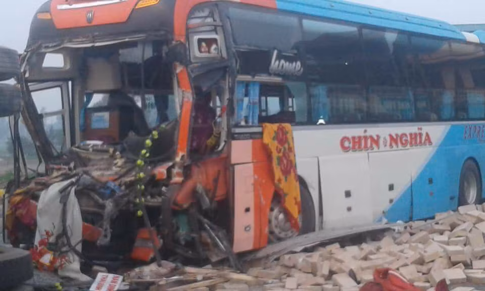 Đầu xe khách giường nằm tan nát bên đống gạch.