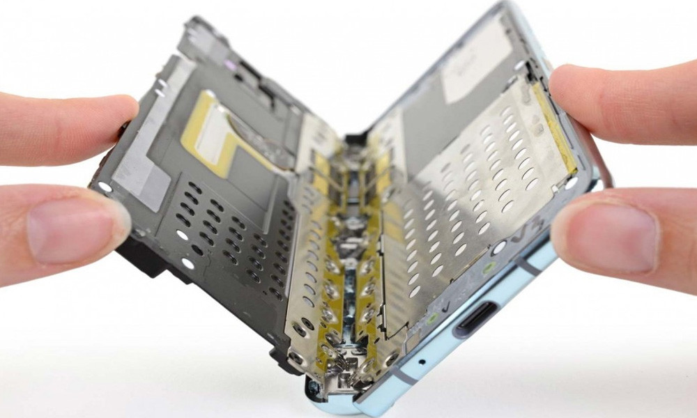 Hai lớp đệm kim loại được thêm vào bên trên và bên dưới bản lề gập mở màn hình. Khoảng cách giữa bản lề và thân máy cũng được giảm xuống. Lớp bảo vệ màn hình được dán rộng hơn, tràn ra hết viền.