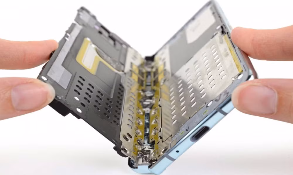 Hai lớp đệm kim loại được thêm vào bên trên và bên dưới bản lề gập mở màn hình. Khoảng cách giữa bản lề và thân máy cũng được giảm xuống. Lớp bảo vệ màn hình được dán rộng hơn, tràn ra hết viền.