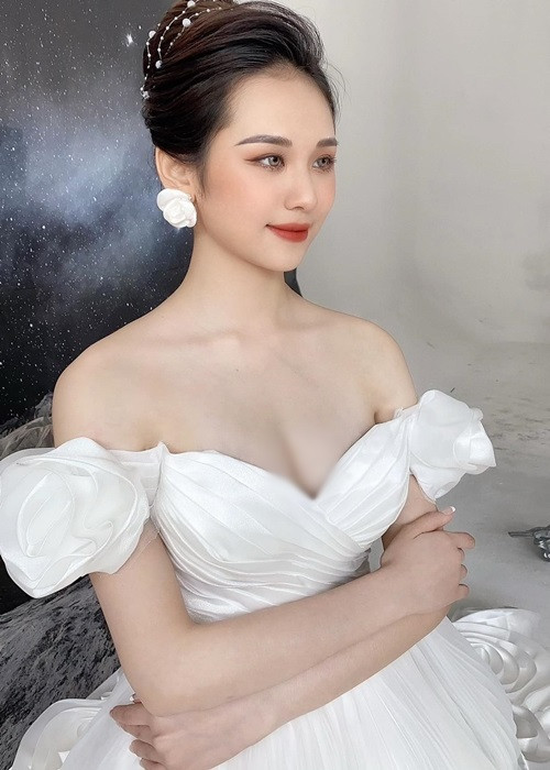 Bà xã kém 10 tuổi của Vũ Duy Khánh diện váy cưới bẹt vai, búi tóc gọn.