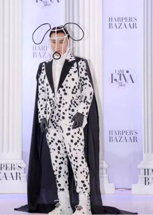 Tại một sự kiện, Trúc Nhân diện vest trắng đốm đen, áo choàng đen, đội chiếc mũ uốn cong hình đầu cún cưng. Ảnh: Vietnamnet