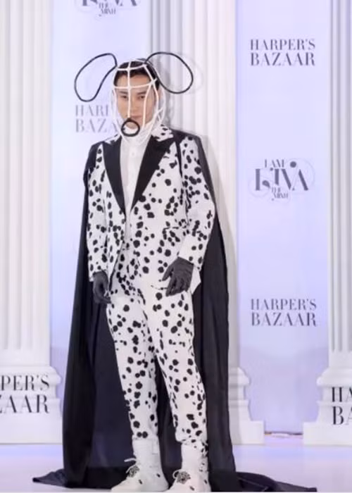 Tại một sự kiện, Trúc Nhân diện vest trắng đốm đen, áo choàng đen, đội chiếc mũ uốn cong hình đầu cún cưng. Ảnh: Vietnamnet