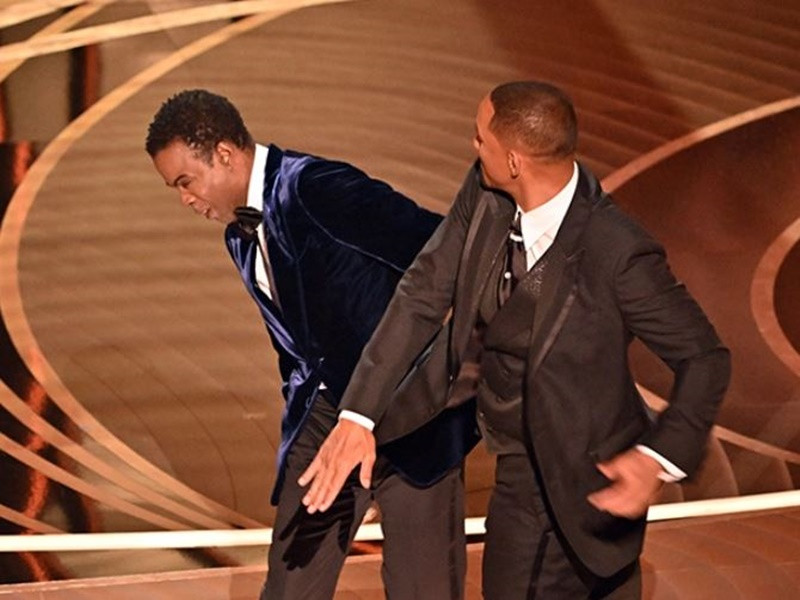 Khán giả theo dõi lễ trao giải Oscar 2022 rất bất ngờ khi Will Smith lên sân khấu tát Chris Rock. Sự việc xuất phát từ việc Chris Rock đùa về tình trạng rụng tóc của vợ Will Smith. Ảnh: Hollywoodlife