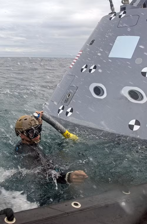 Để có thể thu hồi tàu Orion các thợ lặn của Hải quân Mỹ phải trải qua các khóa huấn luyện đặc biệt với mục tiêu chính là cố định con tàu vũ trụ này với các tàu kéo lai dắt về tàu mẹ (USS San Diego). Nguồn ảnh: QQ.