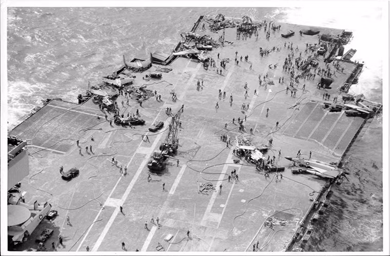 Hình ảnh sàn đáp phía sau của tàu USS Enterprise sau khi đám cháy được dập tắt với các lổ hỏng khá lớn cùng xác máy bay nằm ngổn ngang trên boong.