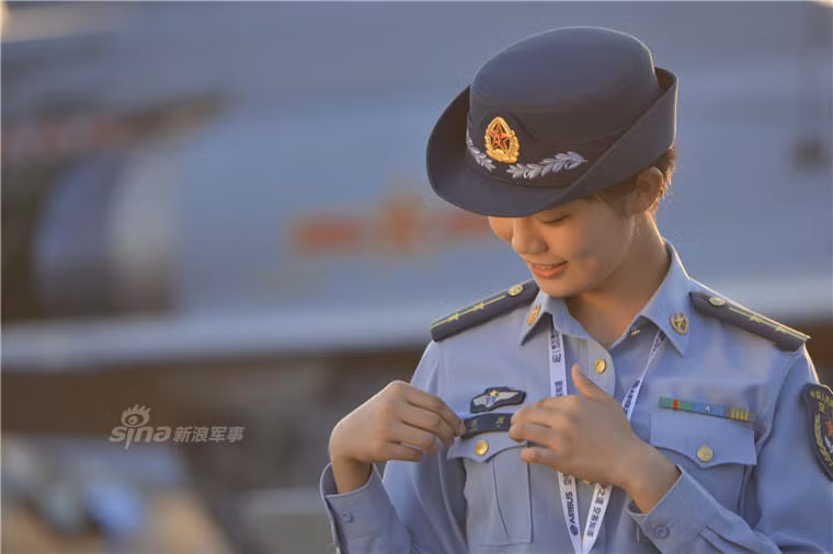 Nữ hướng dẫn viên đang chỉnh lại bảng tên gắn trên ngực áo. Ảnh: Sina