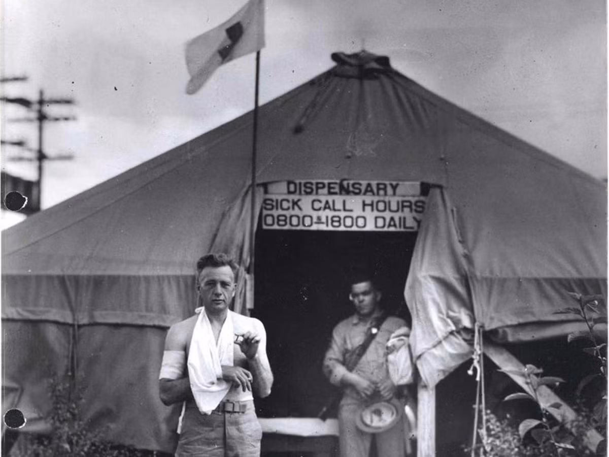 Một binh sỹ Thủy quân Lục chiến bị thương trong trận tập kích bất ngờ của Nhật Bản vào Trân Châu Cảng năm 1941. Người lính trong ảnh đang cầm trên tay một mảnh bom vừa được lấy ra từ bên trong cơ thể mình, phía sau anh là một trạm xá dã chiến. Nguồn Ảnh: U.S.MarineCorpsPhoto.