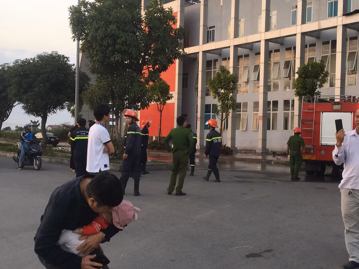 Một ông bố bế con vào lòng thời điểm lực lượng Cảnh sát PCCC đang khống chế ngọn lửa.