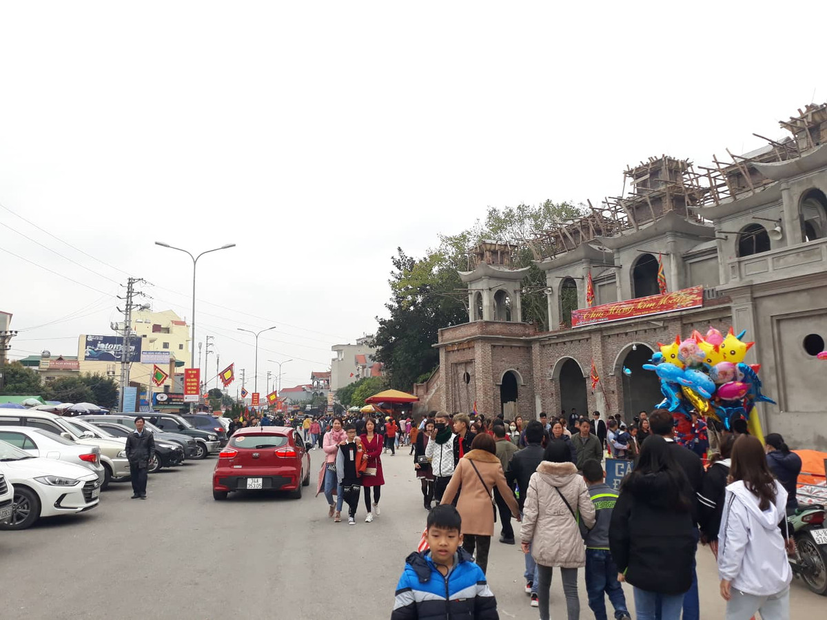 Đường vào đền Tranh, lượng xe đỗ rất đông, dòng người đến đông đúc.