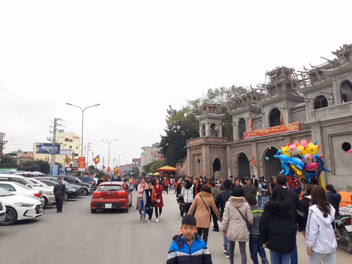 Đường vào đền Tranh, lượng xe đỗ rất đông, dòng người đến đông đúc.