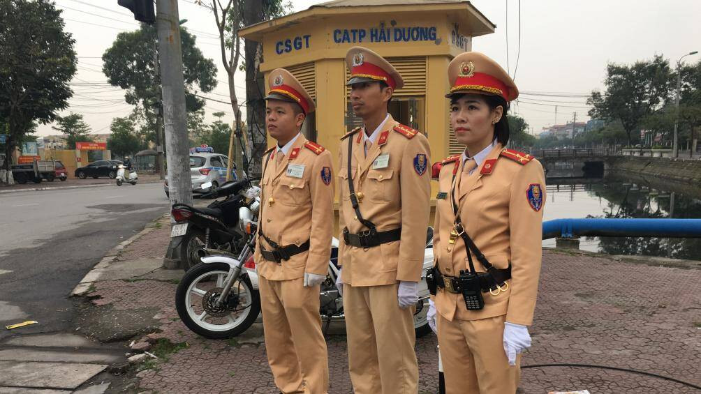 Một nữ CSGT cùng các nam đồng nghiệpthực hiện nhiệm vụ tại điểm giao ngã tư Máy Sứ, TP Hải Dương.