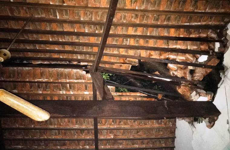 Cả căn nhà của bà Cần bị hư hỏng nặng, có nguy cơ đổ sập bất cứ lúc nào do 2 cây xanh to lớn ngã đè.