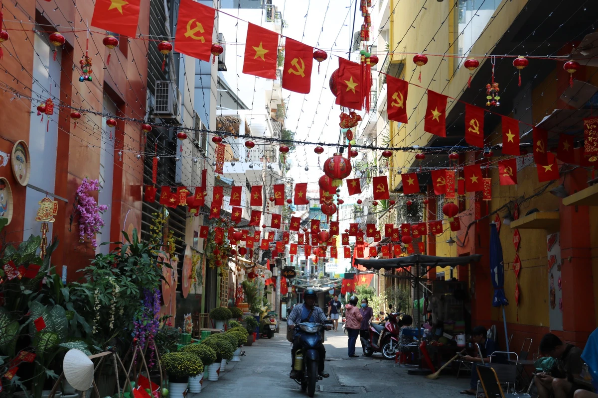 Tương tự, hẻm 100, đường Trần Hưng Đạo cũng rực rỡ cờ đỏ sao vàng những người cận Tết.