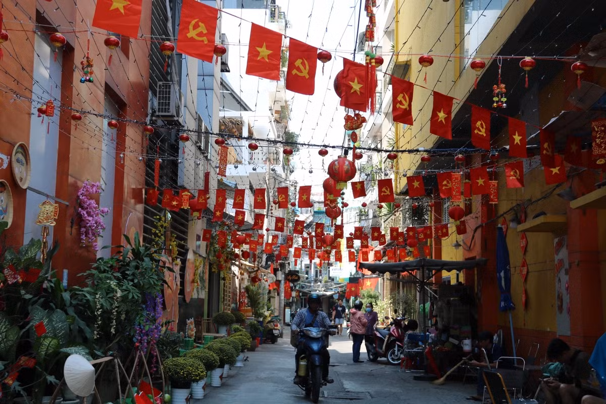 Tương tự, hẻm 100, đường Trần Hưng Đạo cũng rực rỡ cờ đỏ sao vàng những người cận Tết.
