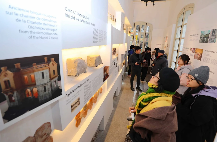 Ngoài các hình ảnh ghi lại quá trình trùng thu, trưng bày còn giới thiệu một số hiện vật như cấu kiện gỗ cũ của ngôi biệt thự, đôi găng tay của người thợ... Ảnh: Thanh Tùng/TTXVN