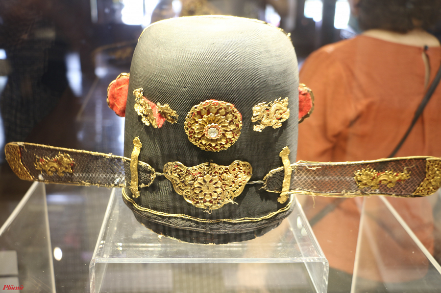 Ở mặt hai bên, mỗi bên trang trí 1 kim khóa nhãn. Mặt sau gồm 2 hoa, 2 giao long, 2 kim như ý. Còn 2 cánh chuồn, ở đầu mỗi cánh được bịt 2 trang sức, giữa mỗi cánh trang trí 2 giao long. Tất cả đều được làm bằng vàng và đều được lót phía sau một miếng vải đỏ.