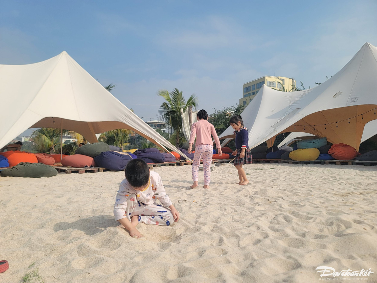 Trẻ em vui vẻ nô đùa với cát trắng.