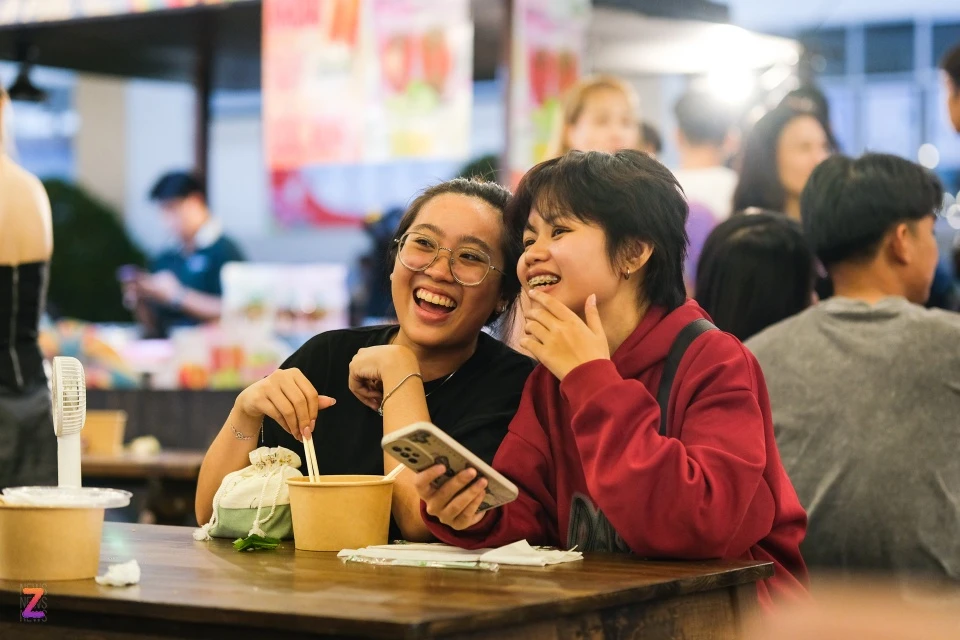 Nhật Vy (áo đen, ngụ TP Thủ Đức) và bạn sau khi tham dự sự kiện trong Trung tâm thể thao cũng dạo quanh và thưởng thức một số món ăn tại đây. "Không gian ở đây trang trí đồng bộ, đẹp hơn nhiều hội chợ ẩm thực khác. Đồ ăn khá hợp khẩu vị, giá cả từ 40.000-50.000 đồng/món", Vy nói.