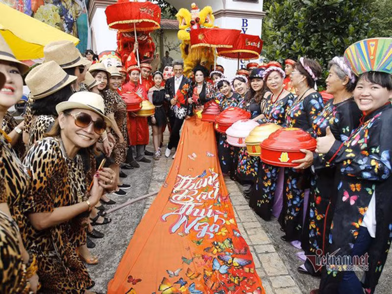 Bà Thúy Nga diện trang phục truyền thống với đuôi áo dài 5m, in tên Thanh Bạch - Thúy Nga. Ảnh: Vietnamnet