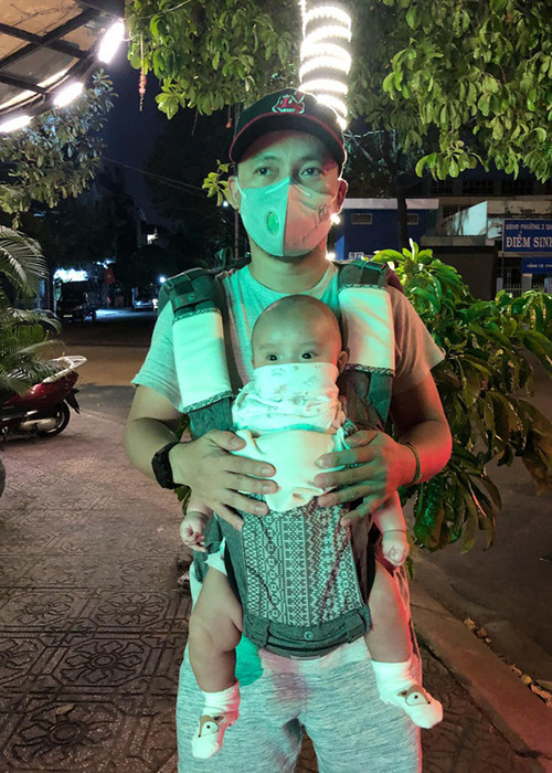 Giữa đại dịch virus Corona, Tiến Đạt đeo khẩu trang trong khi con trai của nam rapper được che chắn bởi khăn sữa.