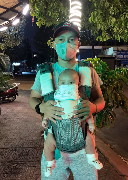 Giữa đại dịch virus Corona, Tiến Đạt đeo khẩu trang trong khi con trai của nam rapper được che chắn bởi khăn sữa.