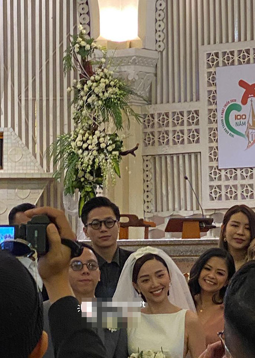 Tóc Tiên diện váy cưới trắng khá đơn giản trong khi Hoàng Touliver diện vest màu ghi. Ảnh: Hóng hớt showbiz