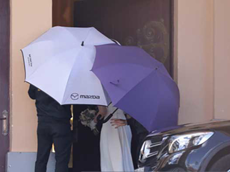 Cô dâu được che chắn bằng ô khi mặc váy trắng bước vào nhà thờ. Ảnh: Thời đại plus