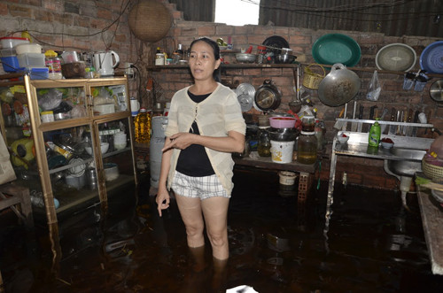 Bà Kim đang đứng giữa căn bếp chìm sâu trong nước của mình vào chiều 21/9. Nhiều tài sản, vật dụng và ngay cả vật nuôi cũng phải đưa lên cao, sống trên giường để tránh cảnh nước ngập.