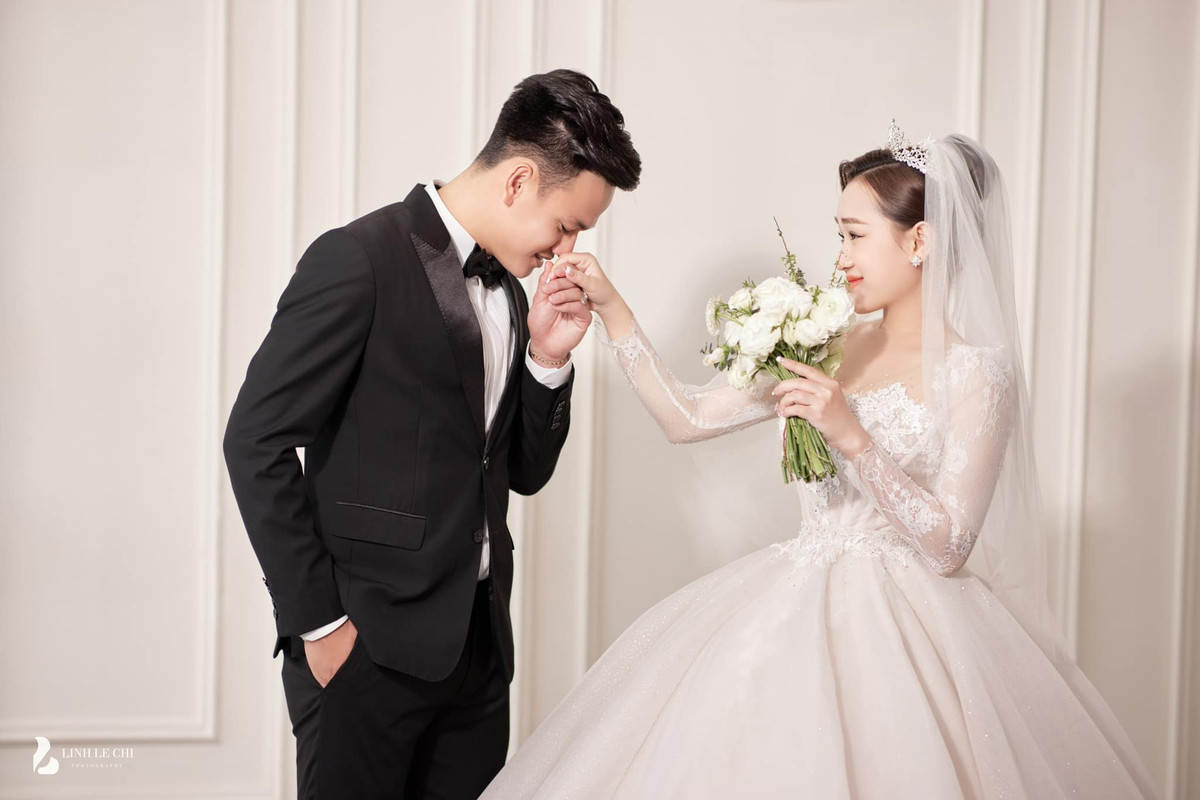 Trong loạt ảnh, Phạm Thị Hiếu chọn váy cưới trắng đơn giản nhưng không kém phần hiện đại, chú rể bảnh bao trong bộ vest.